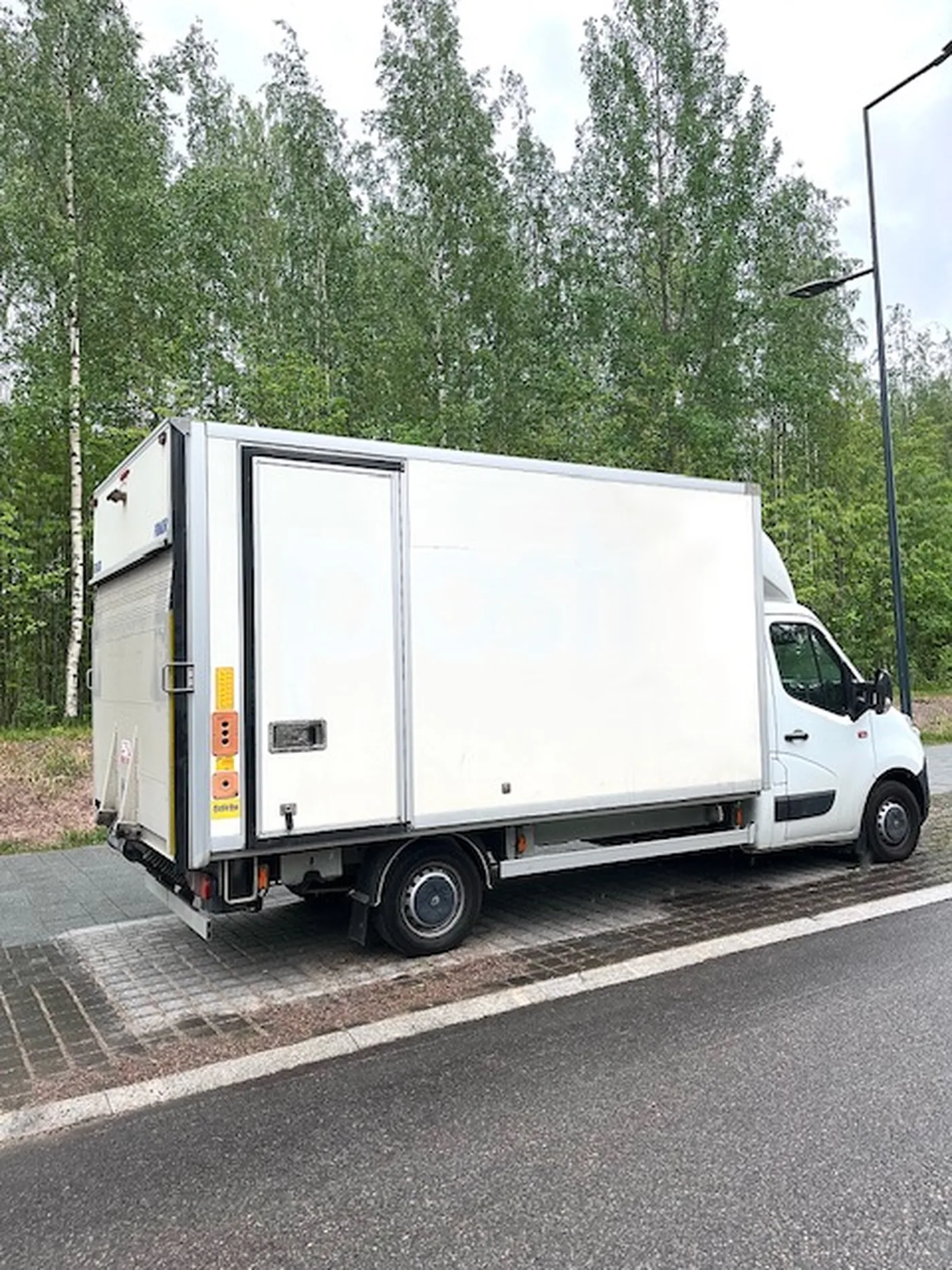 Nordicos Groupin 20 m³ muuttoauto takalaitanostimella koivujen edessä